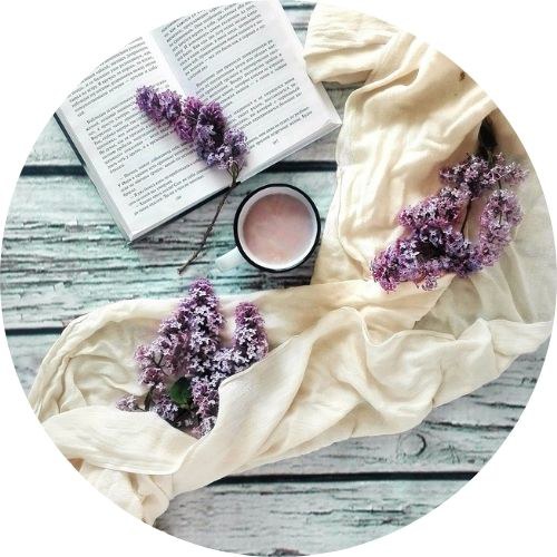  Libro, tazza, sciarpa e fiori disposti su un tavolo. Vista dall'alto